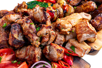 Grilled meat platter with fresh vegetables on wooden board