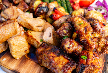 Delicious grilled meats on a wooden platter at a summer barbecue