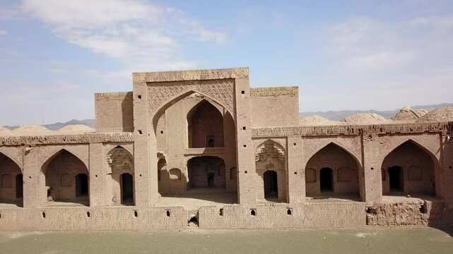aramgah asrar in khorasan iran. Drone aerial view of ancient caravanserai ruins in the desert with standing brick arches and surrounding open land, showcasing Persian architectural heritage