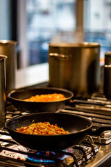 Kitchen in a cafe, cooking, frying pans on the background of a pan on a gas stove