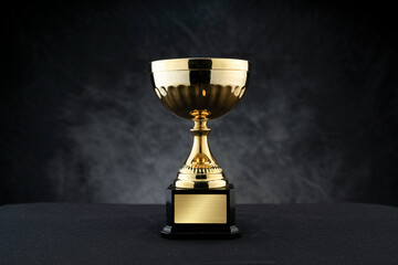 Golden Trophy Placed On A Table Depicting Victory Achievement And Championship Success With Dark Background