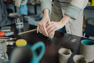 Ceramist kneading clay for pottery creation in workshop