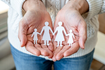 Paper Family Figures Held In Caring Hands Symbolizing Protection And Support For A Happy Future