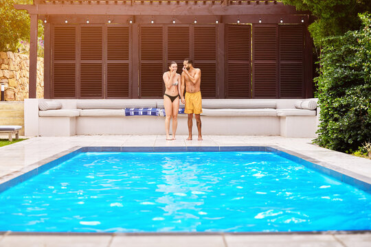 Swimming pool, couple and holding hands outdoor for relax, travel and summer at luxury hotel as holiday. Water, people and sun for wellness, hospitality and vacation at resort in Bali with freedom