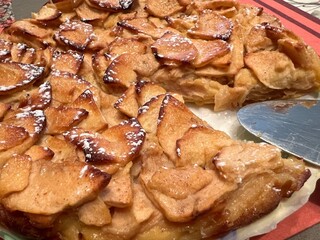 Cuttting a piece of homemade apple pie baked in an oven