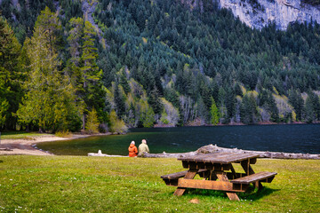 Couple sitting on a bench, near the beach at horne lake provincial park, vancouver island, british colombia, canada 