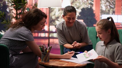 Teen girl participates in a drawing activity as part of psychotherapy, helping her express feelings and intrusive thoughts. Session to overcome personal struggles through art. Camera A.