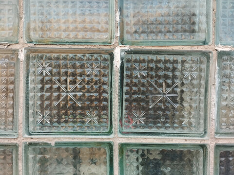 A section of a glass block wall from multiple square blocks with textured surfaces. Suitable for illustrating architectural details or textured backgrounds