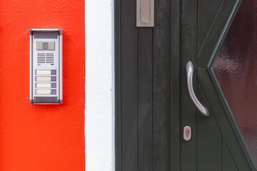 Door intercom on red wall in Burano Italy