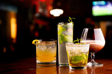 collection of refreshing cognac drinks and cocktails with crushed ice and blurred pub background