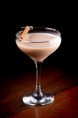 marula milk liqueur cocktail with cinnamon isolated on wooden table
