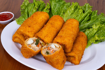 A white plate holding an Indonesian rissole revealing its delicious stuffed filling background