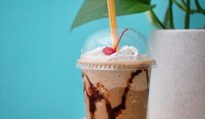 Vaso de frappe con una cereza y chocolate a los lados 