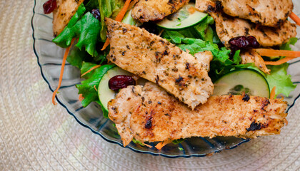 Plato a detalla de tiras de pollo asadas en una ensalada