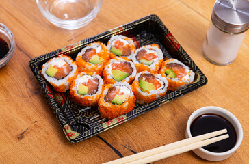 Japanese california roll masago caviar with salmon, avocado and cheese with soy sauce