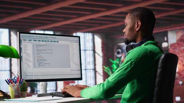 Tech savvy black engineer developing secure online program at home. Surrounded by binary data, freelancer works on interface design, script optimizations and network systems. Camera A.