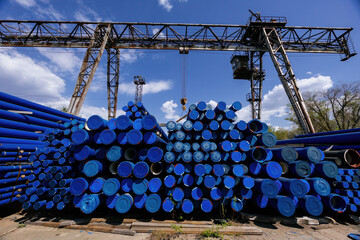 Stack of cast iron pipes in loading area waiting for transportation