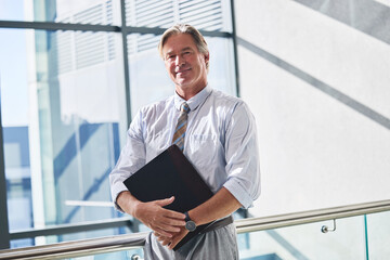 Fototapeta premium File, portrait and smile with business man in office for audit or tax review of financial documents. Accounting, finance and info with mature corporate employee in workplace for professional work