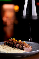 duck magret served with parmesan cream paired with a glass of red wine