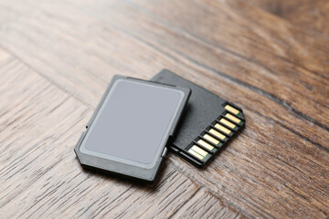 Two SD memory cards on wooden table, closeup