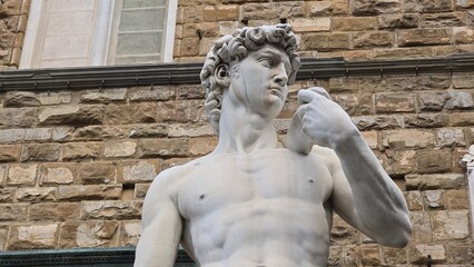 Florence, Italy - 3 January 2025. Close-up of the replica of Michelangelo's David, with the detailed upper body, intense gaze, and hand holding a sling, located in Piazza della Signoria, Florence.