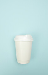 Paper coffee cup placed on a blue background, Top view. Flat lay, suitable for branding or marketing use