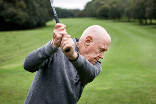 Golf, old man and swing on grass for game, sports club and playing for weekend hobby in retirement. Hit, course and person on green lawn for competition, outdoor challenge and senior golfer on field.