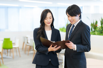 Obraz premium オフィスで打ち合わせをする若い男女のビジネスマン