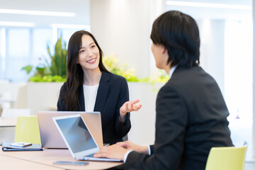 Obraz premium オフィスで打ち合わせをする若い男女のビジネスマン