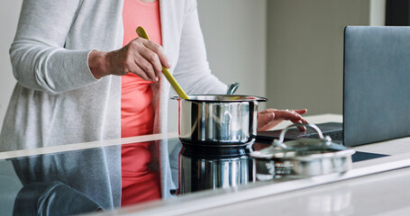 Woman, hands and cooking on stove with laptop, recipe and reading a blog about food. Kitchen, pot or person mixing with wood spoon, scroll online or learning to prepare meal or dinner with nutrition