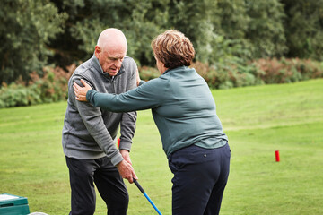 Sports, golf and senior man with help for game, competition and practice on golfing course. Fitness coach, retirement and people with club for training, match and exercise with personal trainer