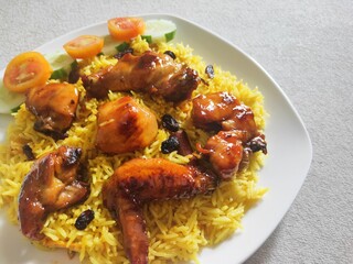 Nasi Biryani or Biryani Rice with honey roasted chicken on a white plate