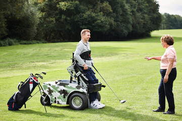 Sports, person with disability and people for golf in game, match and competition on golfing course. Recreation, personal trainer and woman and man with club for training, fitness and field practice