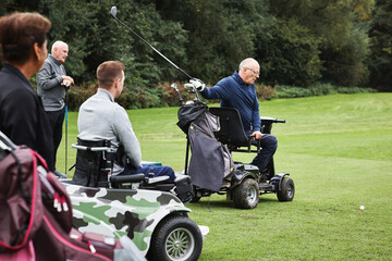 Sports, swing and men in wheelchair for golf in game, match and competition on golfing course. Recreation, hobby and senior man with person with disability with club for training, fitness or practice