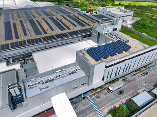 Solar-powered warehouse facility with freight trucks at loading docks. Eco-friendly logistics and efficient cargo transportation. Solar panels and sustainable energy concept in distribution center.