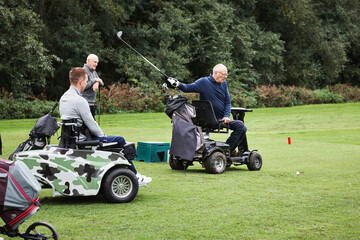 Sports, people with disability and swing for golf game, match and competition on golfing course. Recreation, mobility scooter and senior men with club for training, fitness and practice on field © Dean2000/peopleimages.com