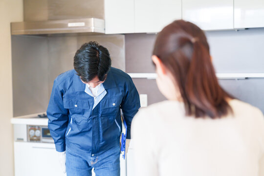 お客様に頭を下げてお詫びをする作業員の男性