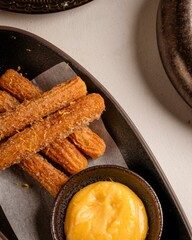 Delicious churros with sweet dipping sauce dessert table food photography cozy restaurant top-down view tempting treats for your cravings