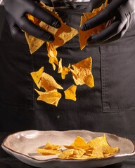 Crispy tortilla chips falling from hands kitchen setting food photography indoor lighting close-up shot culinary art