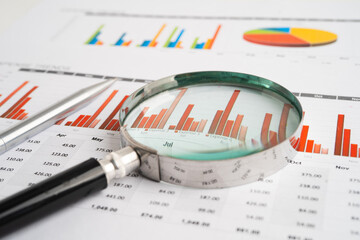 Magnifying glass on spreadsheet and graph paper. Financial data economy, Business.