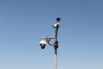 Closed-circuit camera, small CCTV for to small steel pole and steel beam by sky blue is background with natural light. Can record events such as traffic, accidents. Prevent thief. Modern technology.