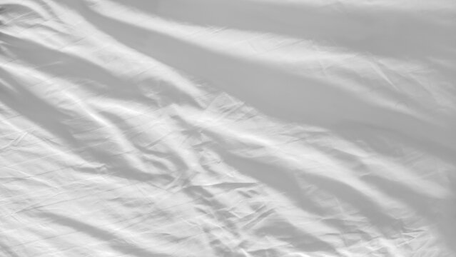 White and wrinkled bed sheet wave background. close up wave fabric.