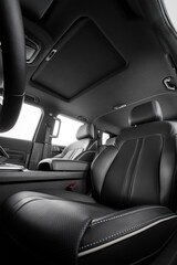 close-up leather, black passenger seat, with seat belts. close-up of the hatch on black roof in luxury 