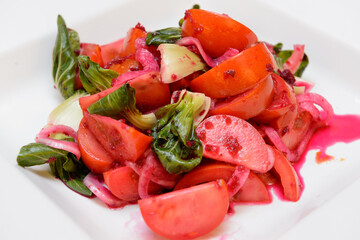 Tomato beet vegetable salad on a white plate
