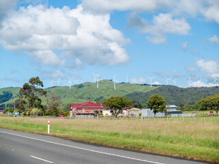 White wind turbines over rural hills