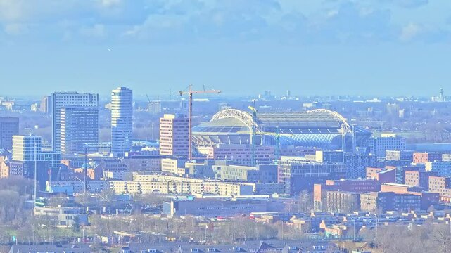 Aerial: Johan Cruyff Arena and cityscape during the day in Amsterdam, Netherlands, establishing drone shot