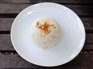 Plain white steamed rice served in a white plate and Plain white steamed rice served in a white plate on wooden table. rice with fried onion topping with fried onion topping