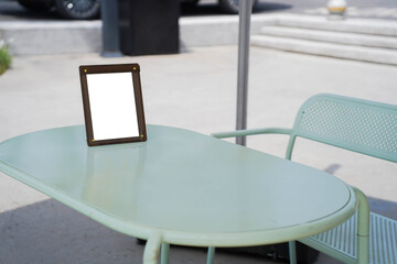 Mockup of a menu frame standing on a table outdoors. Restaurant. Beauty saloon. Bar. Cafe. Place for text..