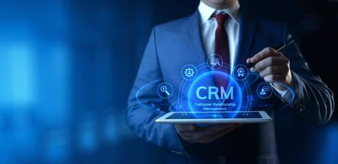 Businessman holding tablet with CRM Customer Relationship Management icons on screen