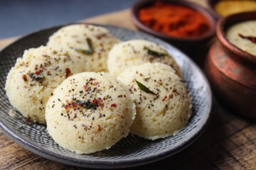 Fototapeta premium Rava Idli is a soft fluffy South Indian dish made from semolina yogurt and spices It s a quick healthy steamed meal often served with coconut chutney and sambar
